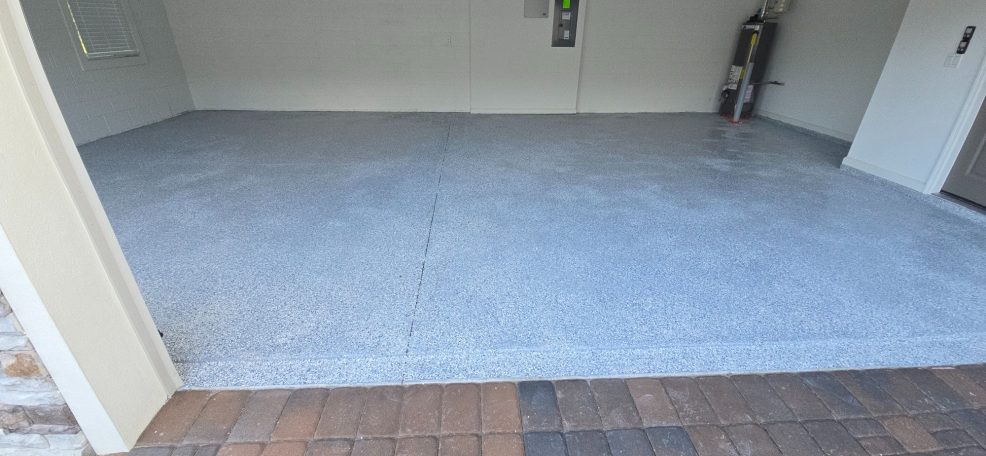 Epoxy Floor Covering Empty garage with a concrete floor and a door leading outside.